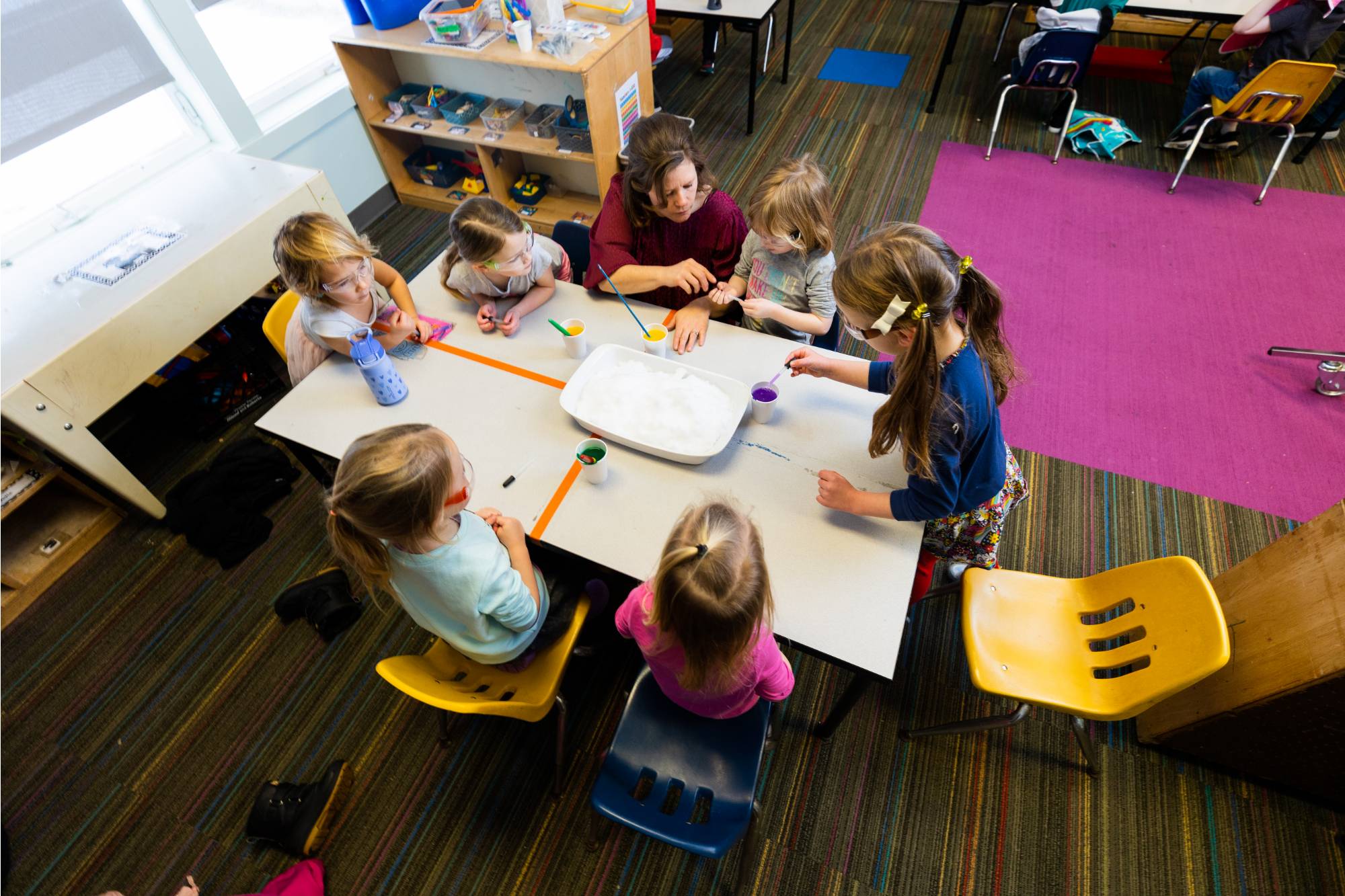 Kids sitting at the table with a teacher